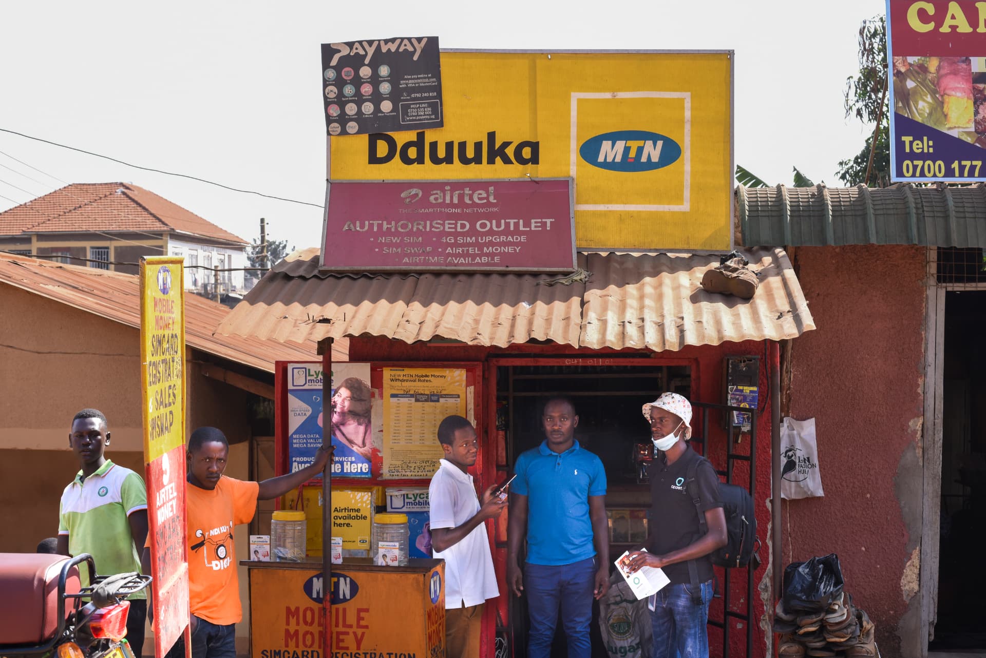 An Opareta mobile money agent serving a customer at a kiosk